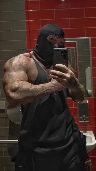 Zade, black balaclava. Mirror selfie in black vest, red tiles.