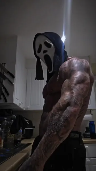 Zade, ghostface. Shirtless side profile, backlit dark kitchen.
