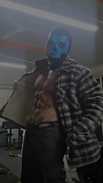 Zade, blue skull mask. Open check shirt, gym.