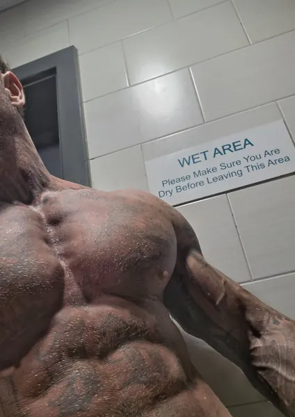 Zade, face hidden. Chest close-up in gym changing room.