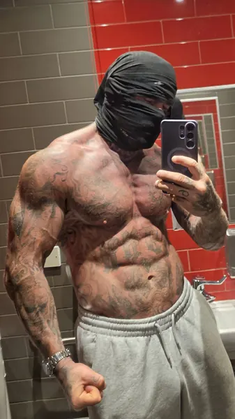 Zade, black face wrap. Shirtless mirror selfie, grey joggers, red tiles.